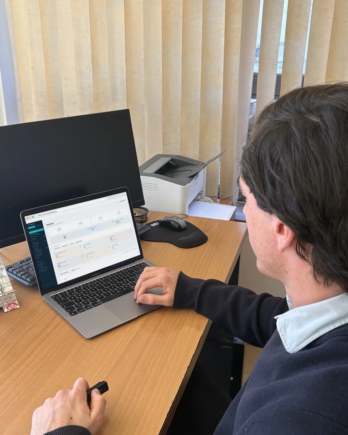 El panel de FORUX abierto en una laptop, en una oficina inmobiliaria